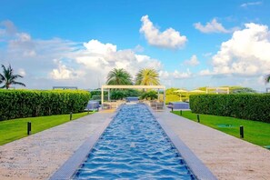 A swimming pool with a clear view of the sky and palm trees in the background. - Azure Aruba-3BR Resort Style Villa by Eagle Beach (Oranjestad)