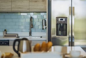 A modern kitchen with a stainless steel refrigerator, a coffee machine, and a kettle. - Azure Aruba-3BR Resort Style Villa by Eagle Beach (Oranjestad)