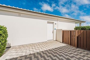 A building with a white exterior, a door, and a wooden fence. - Azure Aruba-3BR Resort Style Villa by Eagle Beach (Oranjestad)