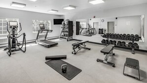 A gym with treadmills, exercise bikes, free weights, and a mirror wall. - Aspen Suites Hotel Fairbanks (Fairbanks)
