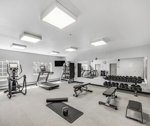 A gym with treadmills, exercise bikes, free weights, and a mirror wall. - Aspen Suites Hotel Fairbanks (Fairbanks)