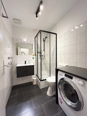 Regadera, secadora de cabello, toallas, papel de baño 