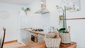 A kitchen with a wooden table, wicker baskets, and white orchids.