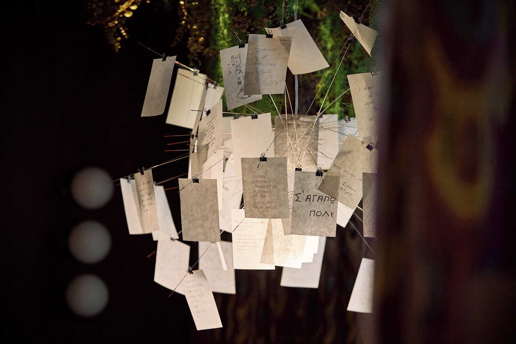 A collection of hanging notes with text, possibly for an event or gathering.