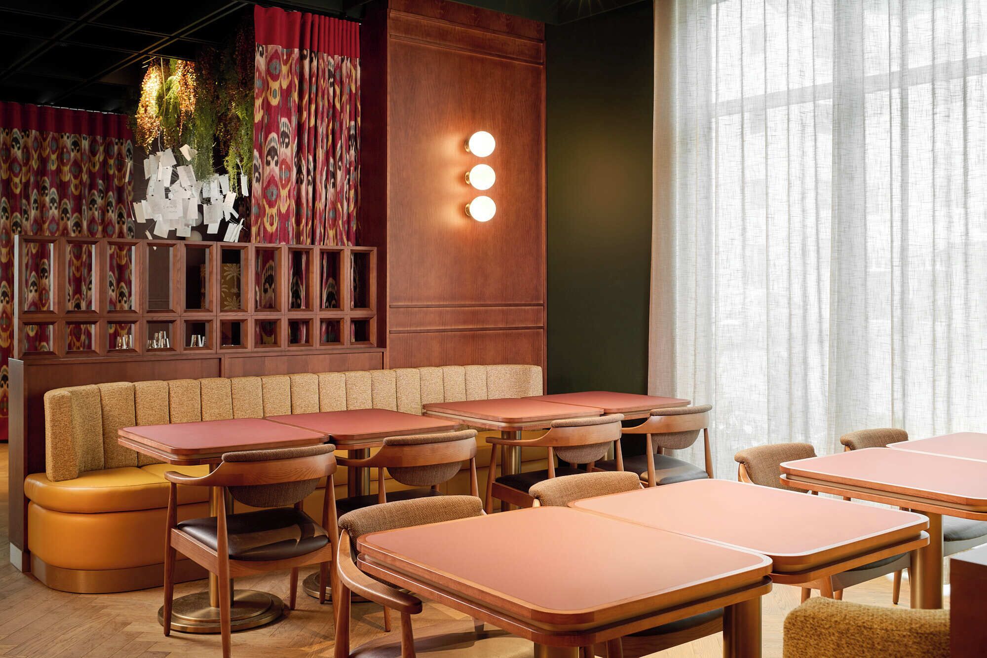 A restaurant interior with booths, tables, and a patterned wall with lights.