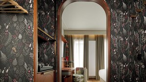 Ein Hotelzimmer mit Holzschrank, Schreibtisch, Stuhl und Bett.