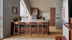 Eine moderne Küche mit Bar, Holzstühlen und Blick auf die Stadt.