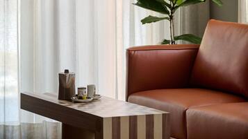 Una sala moderna con un sofá de cuero, una mesa de centro de madera y una planta en maceta.