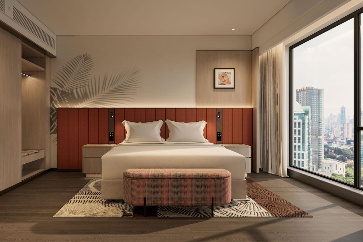 A modern hotel bedroom with a large bed, a city view, and a large window.