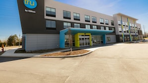 A modern hotel building with a prominent 'tru by Hilton' sign, a covered entrance, and a landscaped area with a small tree. - Tru By Hilton Hazleton (Hazleton)