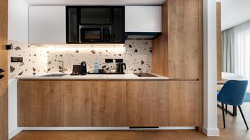 A modern kitchen with wooden cabinets, a microwave, and a coffee maker.