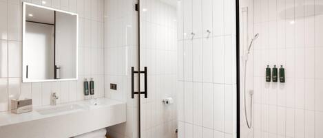 Une salle de bain moderne avec un lavabo blanc, un miroir et une douche.
