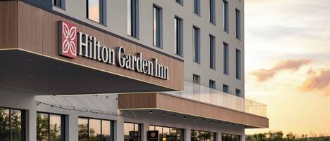 Un edificio moderno con un letrero que dice 'Hilton Garden Inn'.