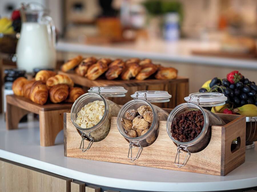 Un buffet de petit-déjeuner comprenant des viennoiseries, des fruits secs et des fruits frais.