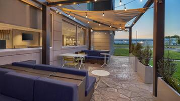 An outdoor patio with seating, a table, and string lights.