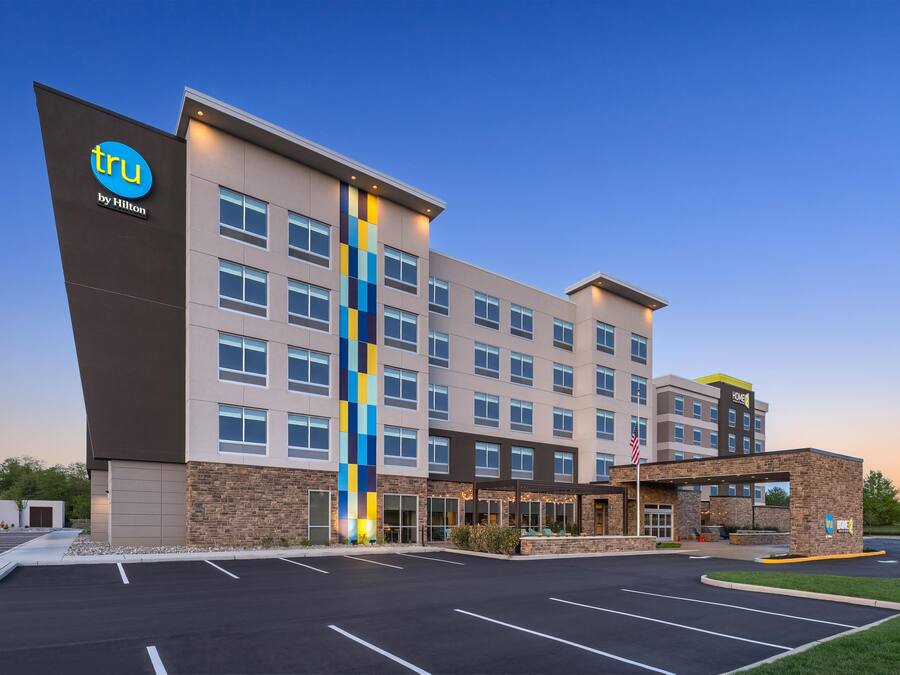 Un hôtel au design moderne, avec plusieurs étages et un parking.