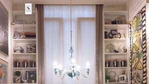 A living room with a chandelier, a flat-screen TV, and a sofa set. - Unique designer apartment in central Sofia Perfect for comfort lovers. (Sofia)
