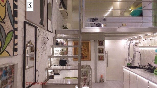 A modern kitchen with white cabinets, a stainless steel countertop, and a mezzanine level with a bed. - Unique designer apartment in central Sofia Perfect for comfort lovers. (Sofia)