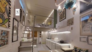 A compact kitchen with a dining area, a staircase, and a small seating space. - Unique designer apartment in central Sofia Perfect for comfort lovers. (Sofia)
