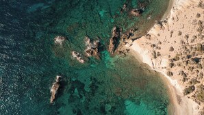 Eine Luftaufnahme einer Küstenlandschaft mit klarem Wasser, Felsformationen und Sandstränden.