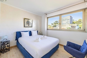 A bedroom with a bed, a chair, a window, and a framed picture on the wall. - Bright Apartment with Terrace and Sea View (Cannes)