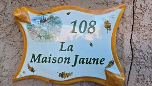A house number sign with a scenic illustration and the text "108 La Maison Jaune". - The yellow house (Vidauban)