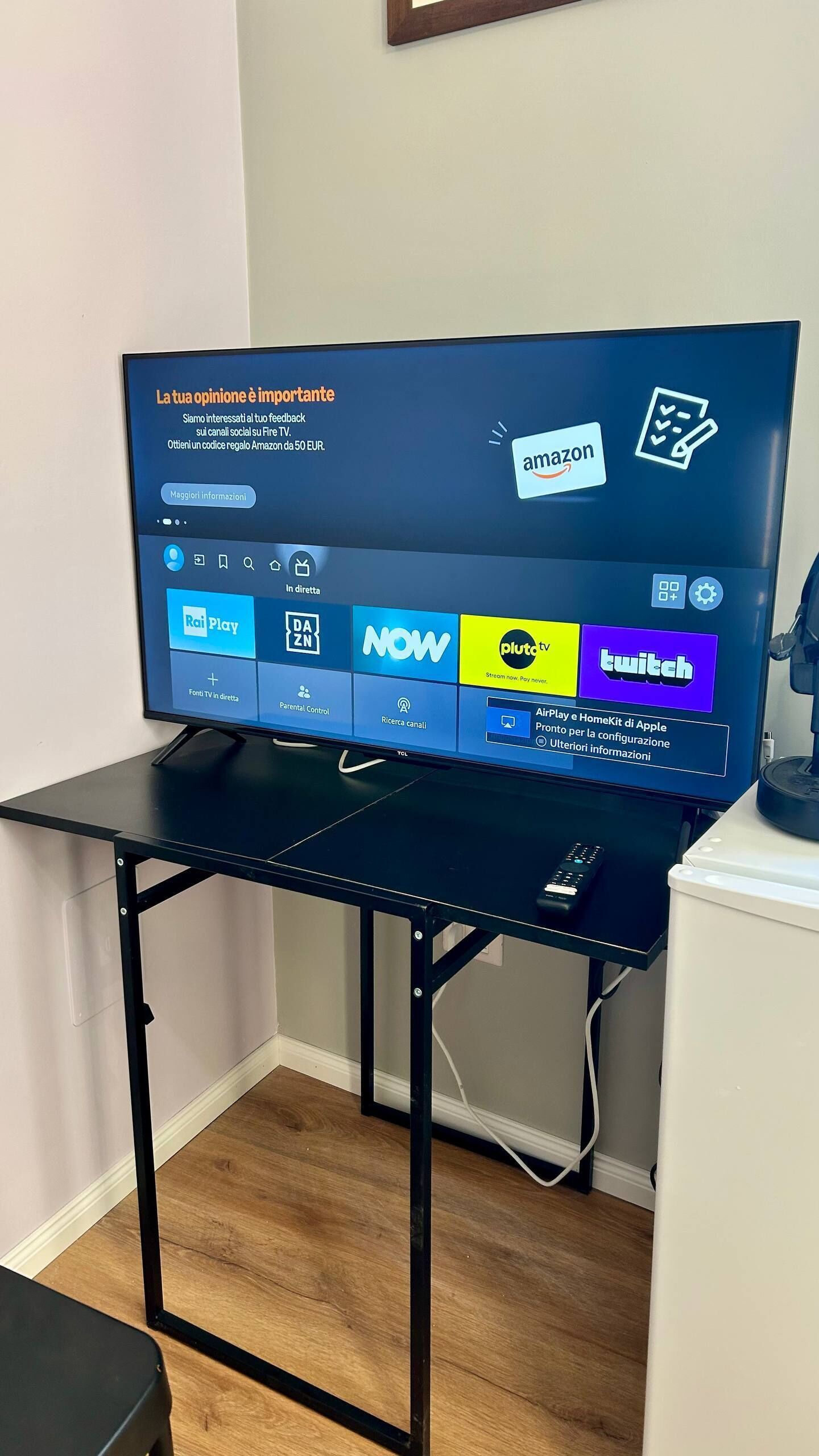 A television on a black metal stand with a screen displaying various streaming services.