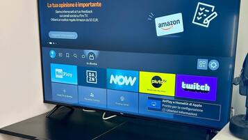 A television on a black metal stand with a screen displaying various streaming services.