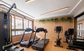 A gym with treadmills, a stationary bike, and a rowing machine. - Fully Equipped Accommodations in a Building With a Pool, 270m From Barra Beach - Caoa (Salvador)