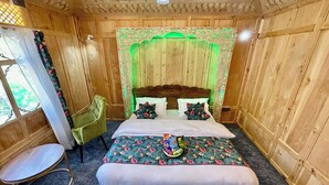 A wooden room with a bed, a chair, and a window with curtains. - The Apollo 11 Heritage Luxury Houseboat (Srinagar)