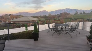 A deck with outdoor seating and a view of mountains. - Utah Vista Chalet: Amazing View Deck, Dual Kitchens & Hot Tub, Games  Sleeps 15 (South Jordan)