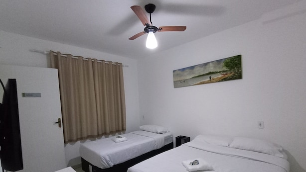 A hotel room with two beds, a ceiling fan, a painting on the wall, and a door labeled "PANDA". - WeStay Budget - Unidade 4 (São Paulo)