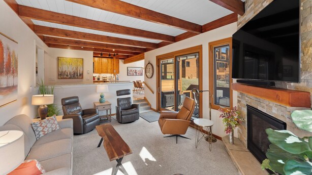 A spacious living room with a fireplace, leather sofas, a coffee table, and a large TV. - Tt1336-3 (Keystone)