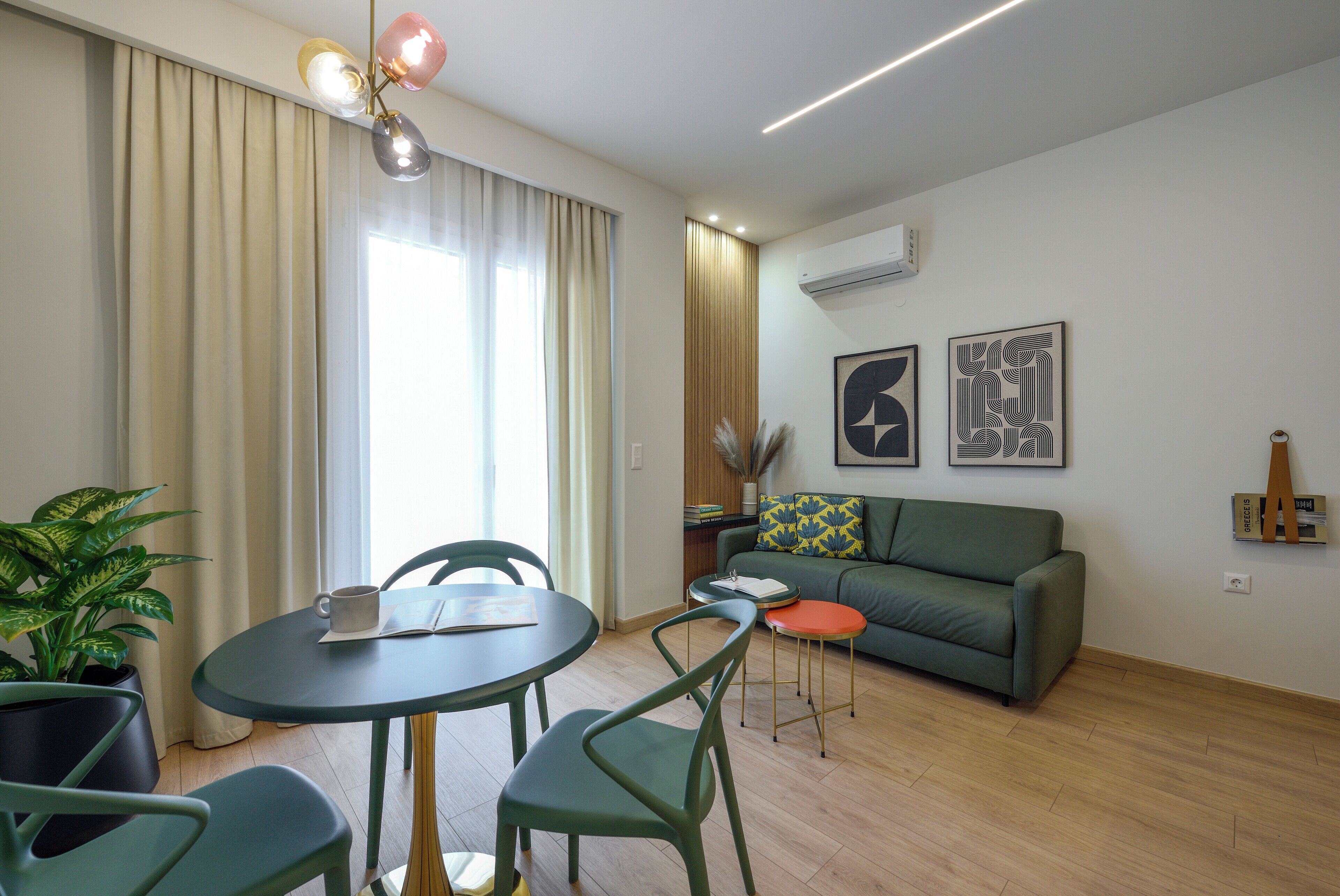 Een moderne woonkamer met een eethoek, een bank, een salontafel en een potplant.