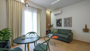 Een moderne woonkamer met een eethoek, een bank, een salontafel en een potplant.