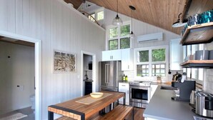 Een moderne keuken met houten vloeren, witte kasten en roestvrijstalen apparatuur.