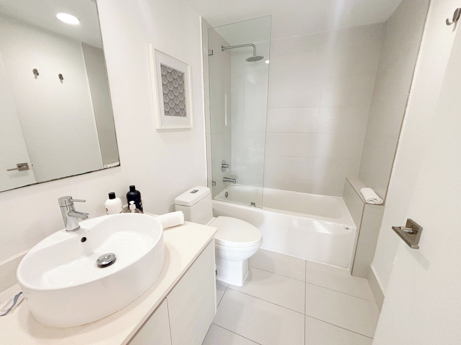 A modern bathroom with a large sink, toilet, and bathtub.