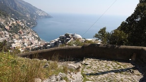 A coastal town with a prominent dome structure, stone walls, and a clear view of the sea. - Villa Dei Srls (Positano)