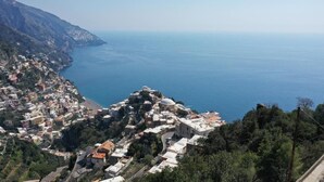 A coastal town with buildings on a hillside overlooking the sea. - Villa Dei Srls (Positano)