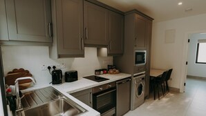 Una cucina moderna con elettrodomestici in acciaio inossidabile, forno integrato e microonde.