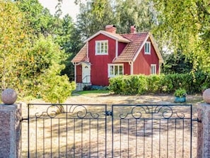 A red house with a fenced yard. - 5 Person Holiday Home in Tving (Tving)