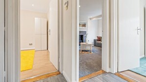 A hallway leading to a living area with a fireplace, a sofa, and a coffee table. - Charming Thames Ditton Apt- Sleeps 6- Free Parking (Thames Ditton)