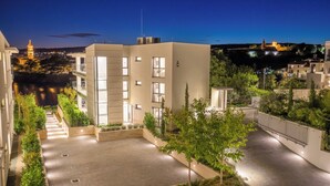 A modern building with a courtyard, surrounded by greenery and a river. - HADRIE Luxury Resort and Villas Krk (Krk)