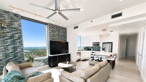 Uma sala de estar moderna com sofá, televisão e área de refeições.