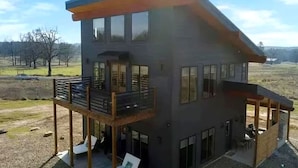 Un edificio de dos pisos con balcón y un patio cubierto.
