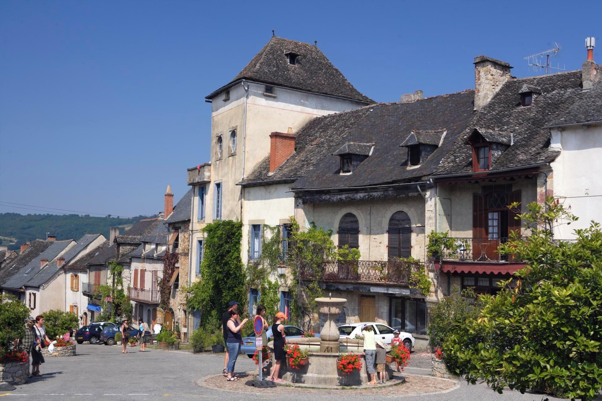 A historic European town with traditional architecture, including stone buildings with tiled roofs and arched windows.