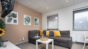 A living room with a grey sofa, a white coffee table, and a radiator.