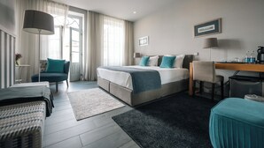 Een moderne hotelkamer met een groot bed, een bureau, een stoel en een klein tafeltje.