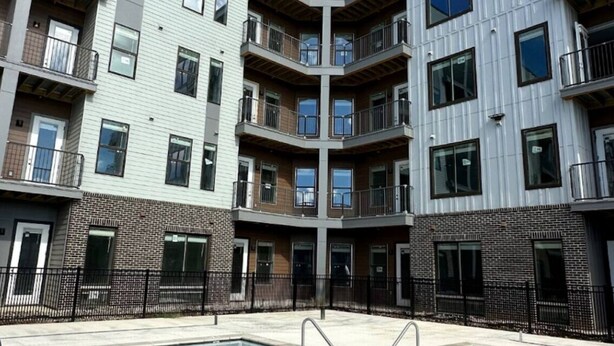 A multi-story residential building with balconies, a swimming pool, and a brick facade. - Charming Apartment with fitness room and in lovely Birmingham (Birmingham)