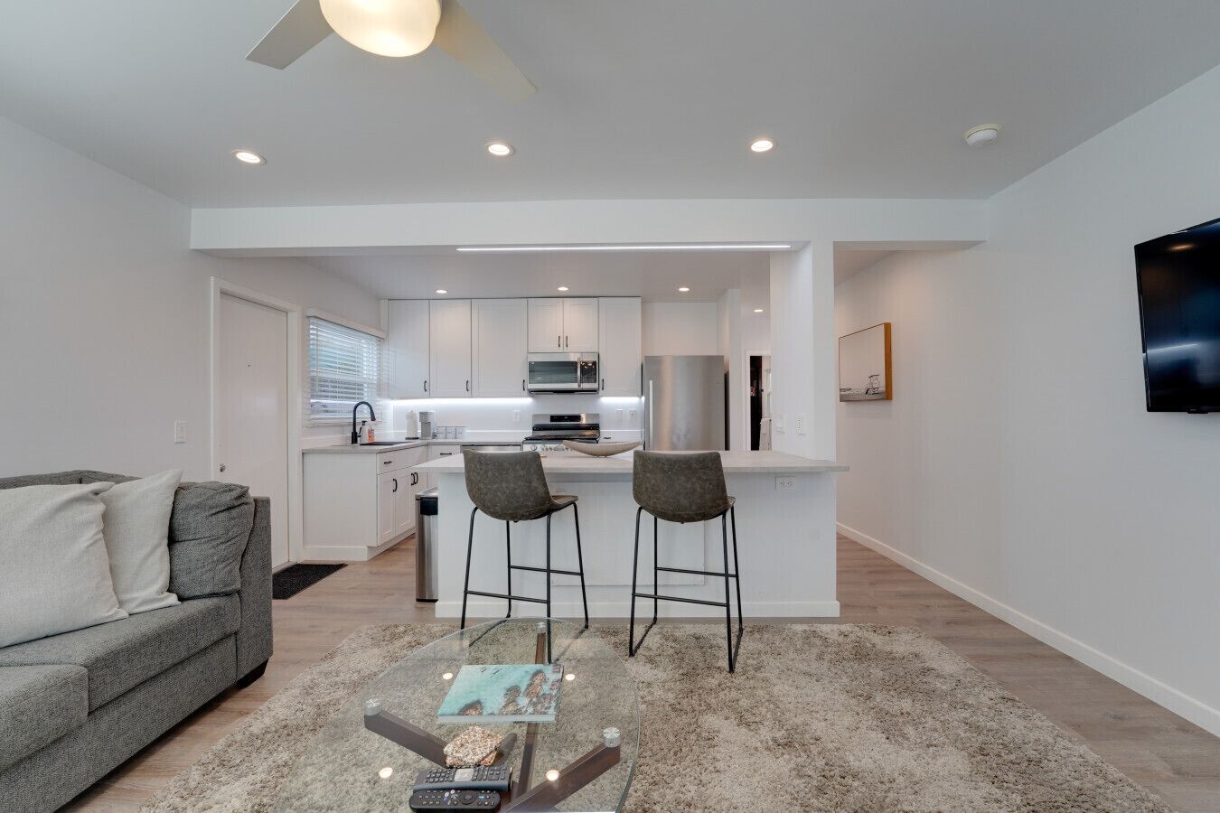 A modern apartment with a kitchen, dining area, and living room.